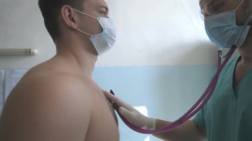 Doctor Listens to Patient Heart with Stethoscope
