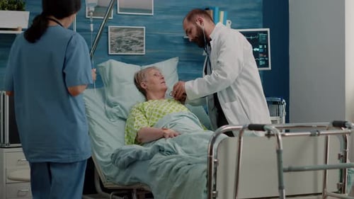 Doctor Examines Senior Woman Patient in Hospital Bed