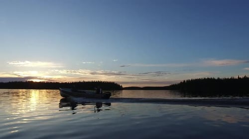 Motorboat sailing on lake at sunset