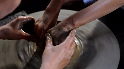 Les mains du potier créent un bocal ou un vase en terre cuite sur un tour de potier.