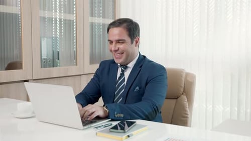 Business man sitting using laptop study online work at his desk success celebration at office