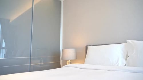 Minimalist Bedroom Interior with White Linens and Lamp