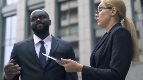 Professionals Discuss Business Outside Building