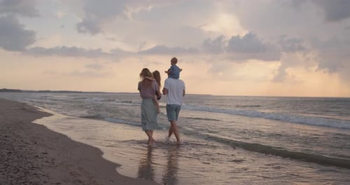 Young Family of Four Walking Down the Beach