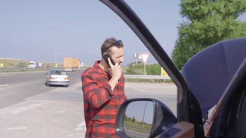 Man on Phone Next to Car on Road