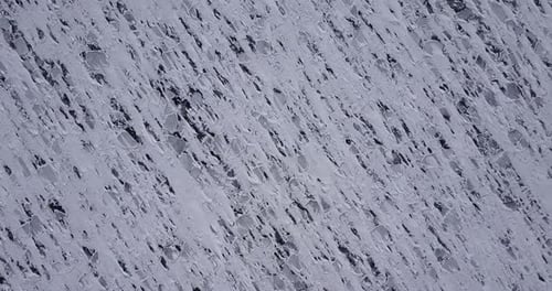 Ice Surface Covered with Snow Rolling Down