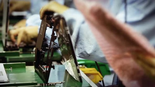 Arbeiter in der Produktionslinie einer Laptop-Fabrik. Schnelle Bewegung. 4K-Version.
