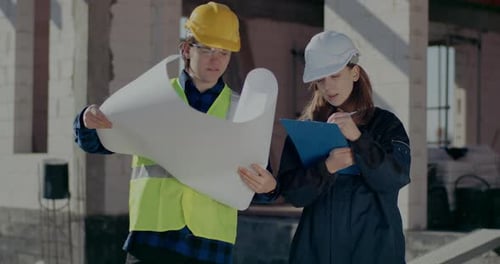 Construction Worker Discussing Blueprint with Supervisor