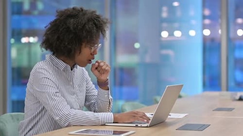 Sick African Businesswoman with Laptop Coughing in Office