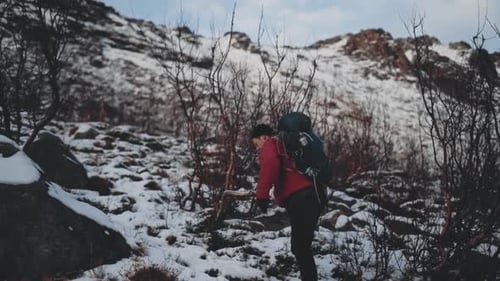 Man Hiking Up Snow Covered Hill