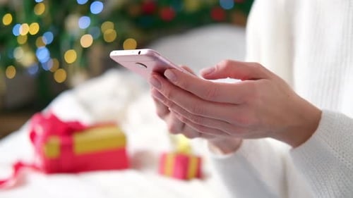 Close Up Woman Hands Using Mobile Phone on Christmas Background