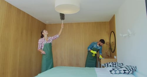 Couple As a Professional Cleaners in Uniform Rubbing Furniture and Wiping Dust in the Bedroom or
