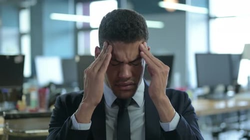 Portrait of Tired African Businessman Having Headache in Office