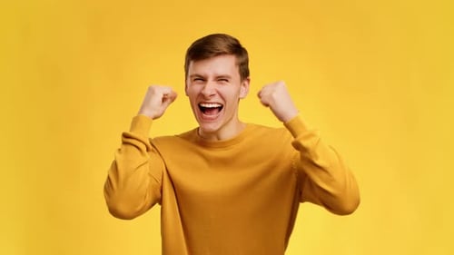 Excited Man Cheering and Pumping Fists on Yellow