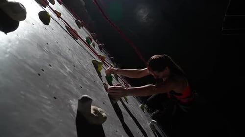 Woman Climbing Rock Wall in Indoor Gym