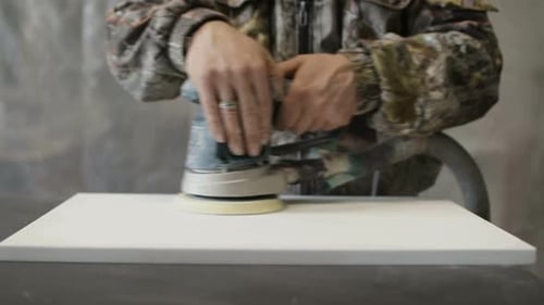 The Worker Polishes the Boards with a Polishing Machine