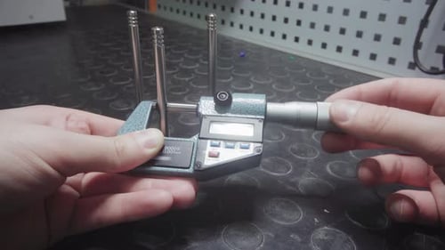 Hands Measure with Digital Micrometer in Laboratory