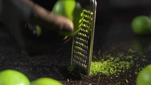 The Cook Grates Ripe Limes on the Grater To Get Zest for Cooking Dessert, Making of the Pastry