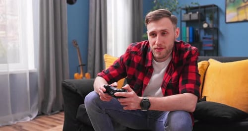 Young Man Playing Video Game on Couch at Home