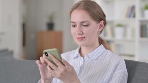 Young Woman Using Smartphone in Bright Interior
