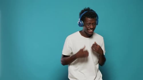 Man Dancing With Headphones in Studio Setting