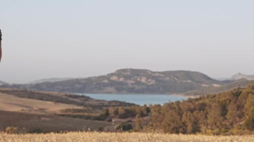 Campo de trigo e lago de longe com o homem em pé no meio
