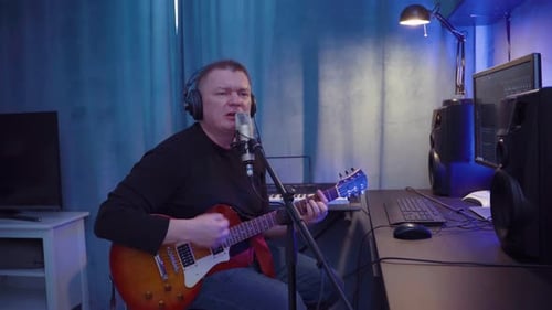 Male Musician With Instrument Guitar Records Songs In Home Sound Studio