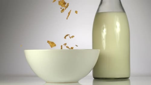 Crispy Flakes Pouring into a Bowl with Milk
