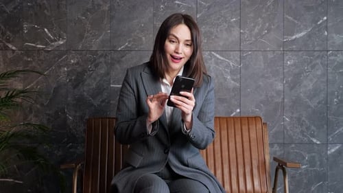 Happy Woman Laughing While Using Her Phone