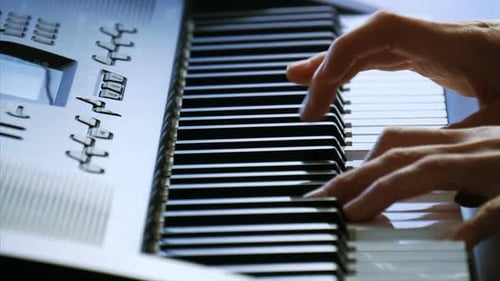 Manos femeninas tocando el piano. Una mujer toca las teclas con los dedos