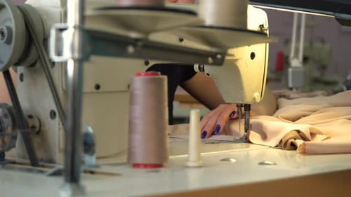 Hands Sewing Fabric with a Sewing Machine