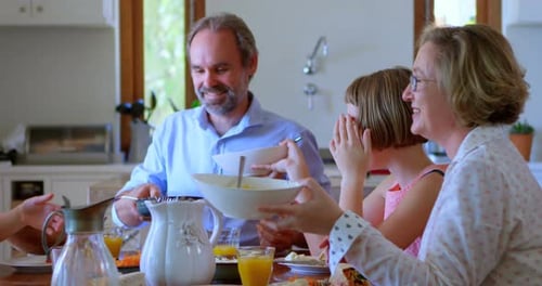 Family Gathered Around Table Eating Lunch Together