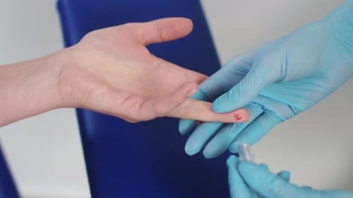 Medical Professional Drawing Blood Sample from Finger