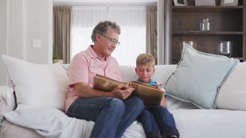 Man and Boy Looking at Photo Album Together