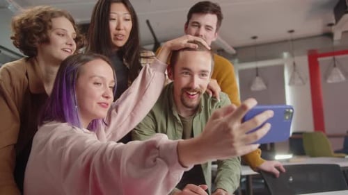 A Group of Five Students are Taking Funny Photos Together Being in the Auditorium in the University