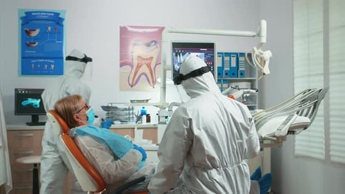 Dentists Consult with Patient in a Clinic