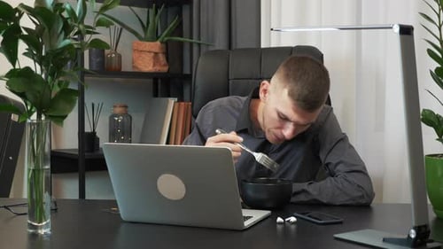 Businessman is taking break on work and eating delivered to the office food.