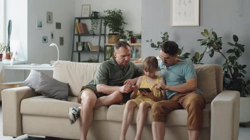 Gay Couple with Child Looking at Smartphone
