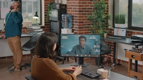 Un employé participe à un appel vidéo avec un collègue pour travailler sur un projet