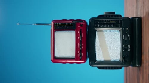 Two Vintage Televisions Displaying Static on Screen