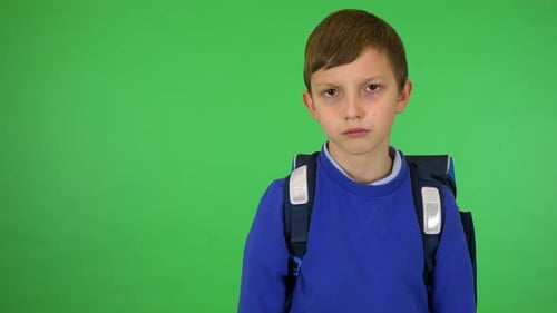 A Young Cute Boy with A Schoolbag Frowns and Shows a Thumb Down to The Camera - Green Screen Studio