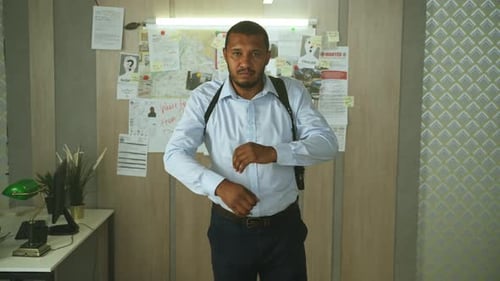Serious Detective Standing With Arms Folded in Office