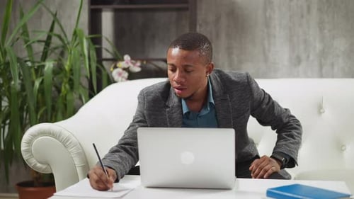 Young Adult Working at Laptop at Home