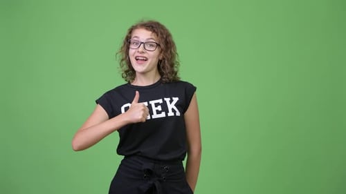 Teenage Girl Gives Thumbs Up on Green Background