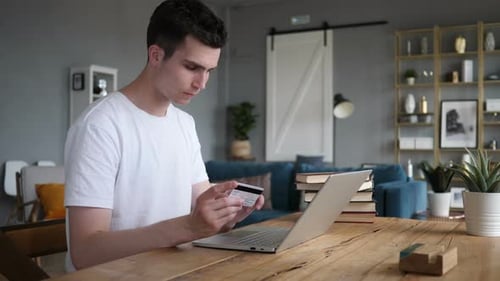 Young Adult Shopping Online with Laptop and Card