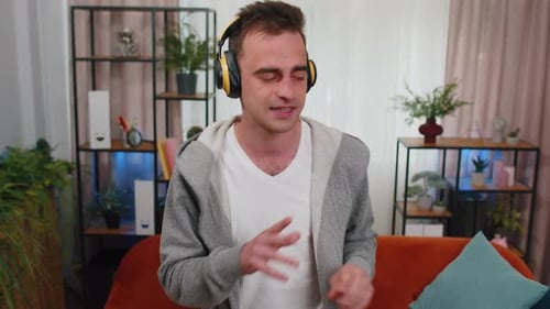 Enthusiastic Man Singing Along with Headphones at Home