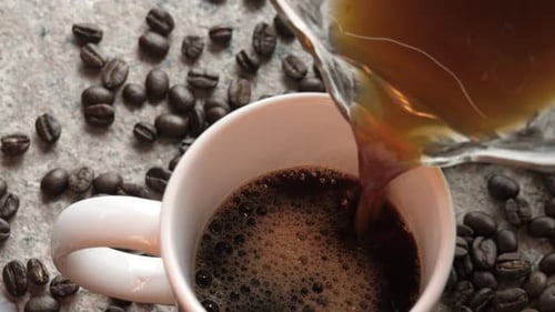 Coffee Pouring into Mug Surrounded by Beans