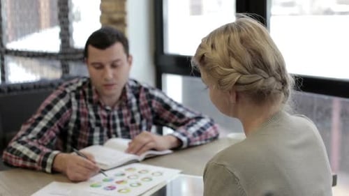 Man and Woman Discussing Business at Modern Office