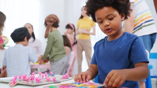 Boy Concentrates on Puzzle in Classroom