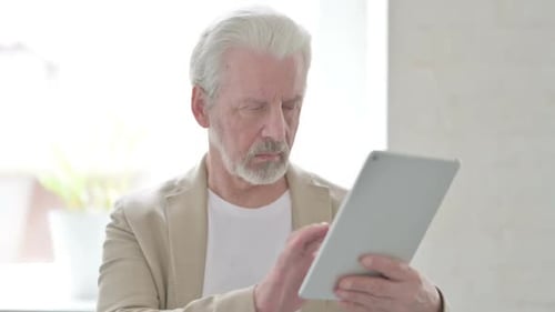 Senior Man Using Tablet Device Indoors